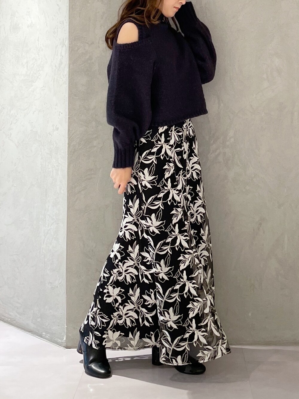 ブルー系のスカート、グレー系のニット/セーターを着用したレディースの秋コーディネートの3枚目の写真