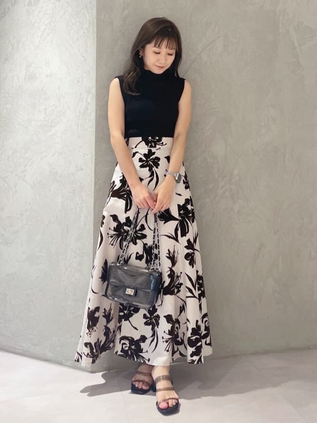 ブラック系のニット/セーター、ホワイト系のスカート、ブラック系のショルダーバッグを着用したレディースの夏コーディネートの7枚目の写真