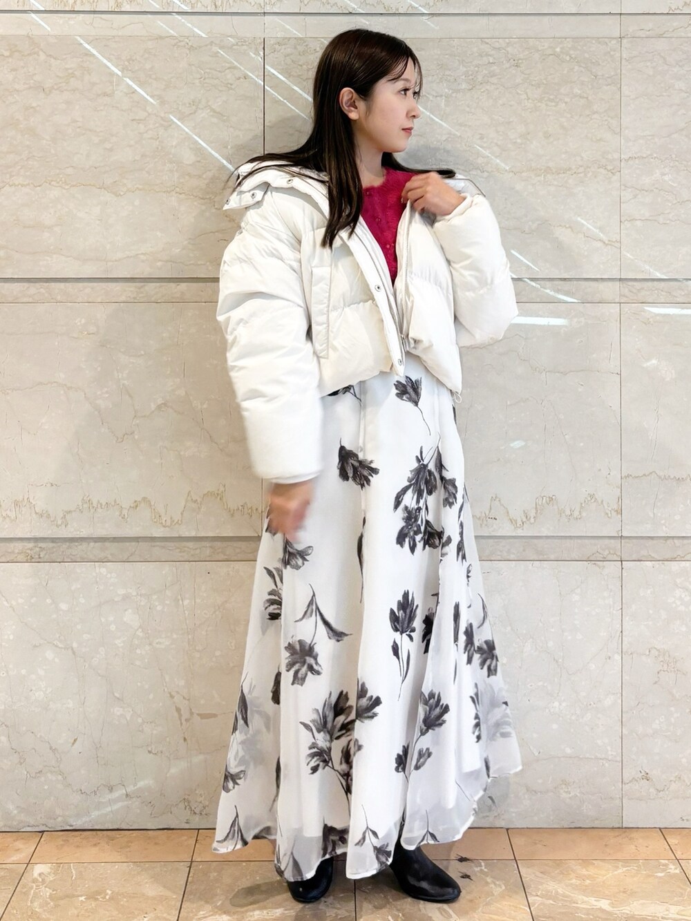 ホワイト系のスカート、ブラック系のブーツ、レッド系のカーディガン/ボレロを着用したレディースの冬コーディネートの2枚目の写真