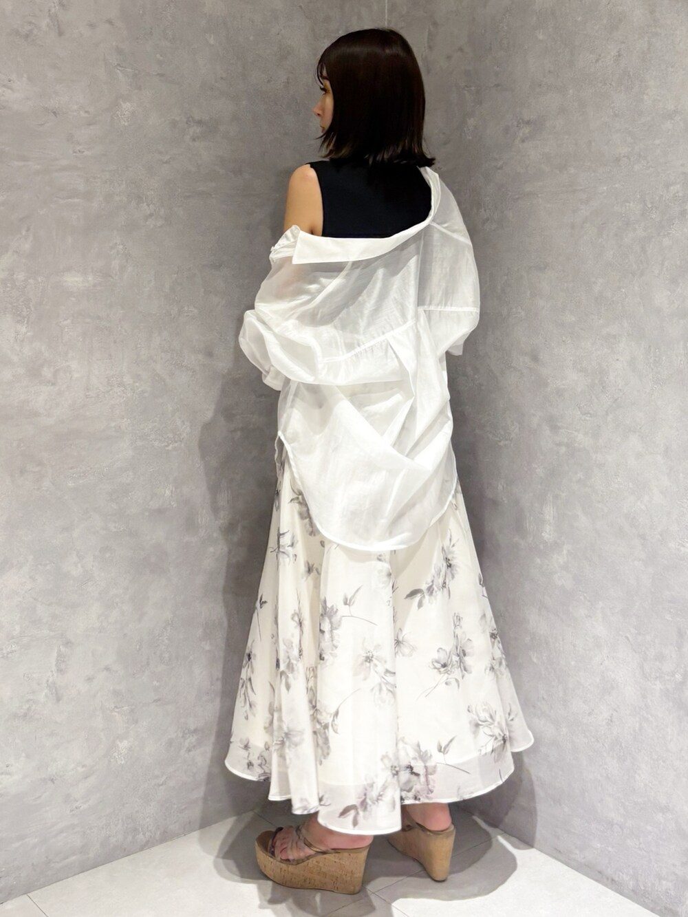 ホワイト系のワンピース、ブラウン系のサンダル、ホワイト系のハンドバッグを着用したレディースの夏コーディネートの2枚目の写真