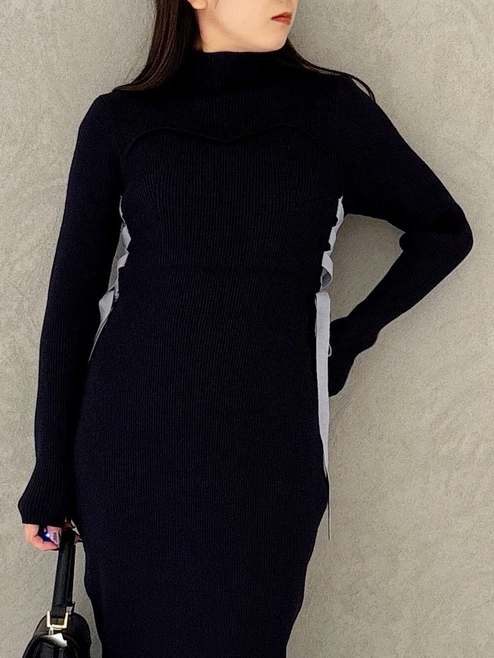 ブルー系のワンピース、ブラック系のブーツ、ブラック系のショルダーバッグを着用したレディースの冬コーディネートの7枚目の写真