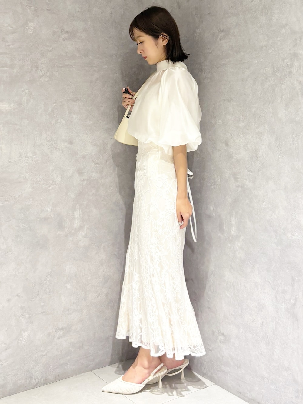 ホワイト系のスカート、ホワイト系のシャツ/ブラウス、ホワイト系のハンドバッグを着用したレディースの春コーディネートの4枚目の写真
