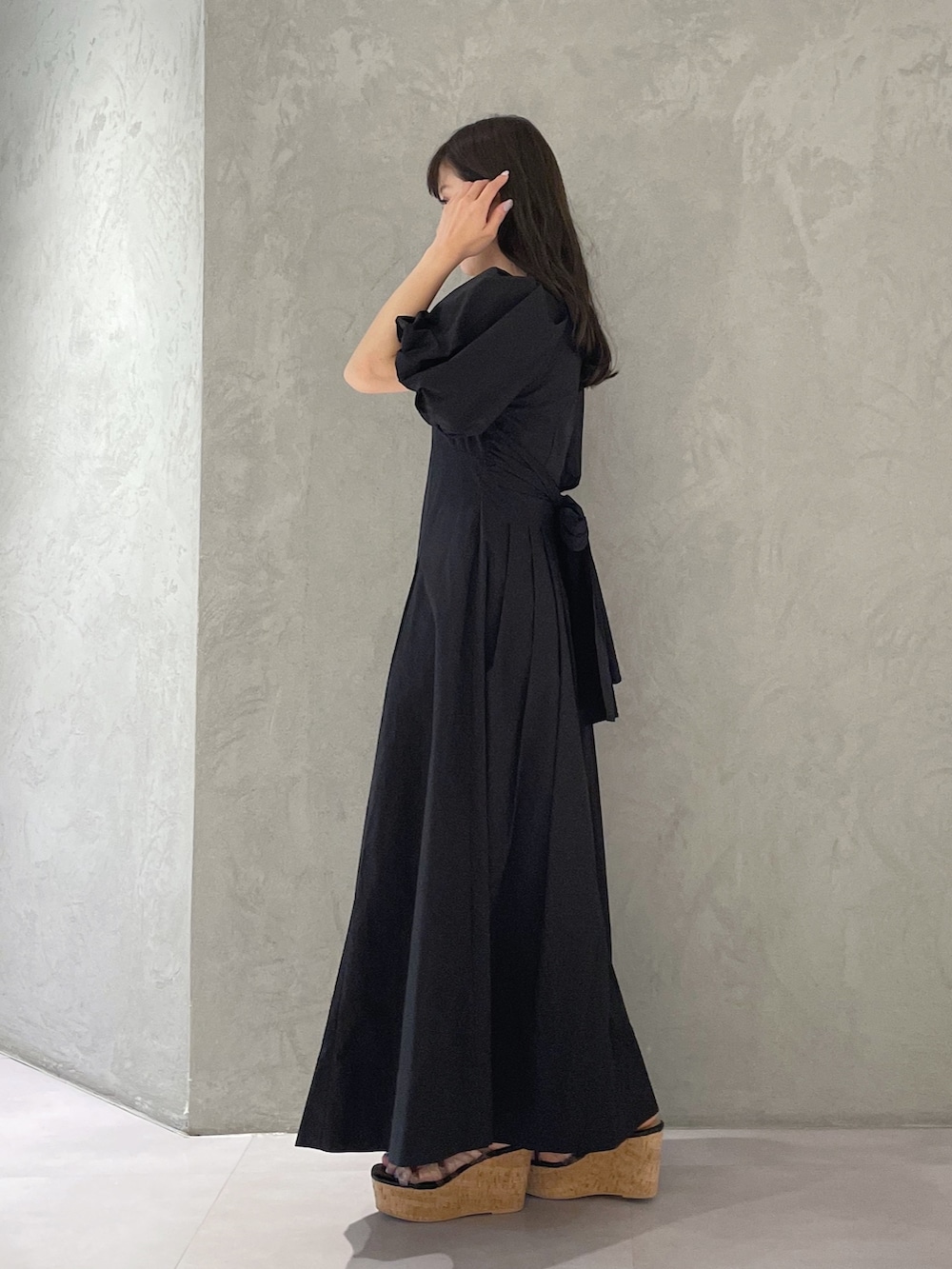 ブラック系のサンダル、ブルー系のハンドバッグ、ブラック系のワンピースを着用したレディースの春コーディネートの3枚目の写真