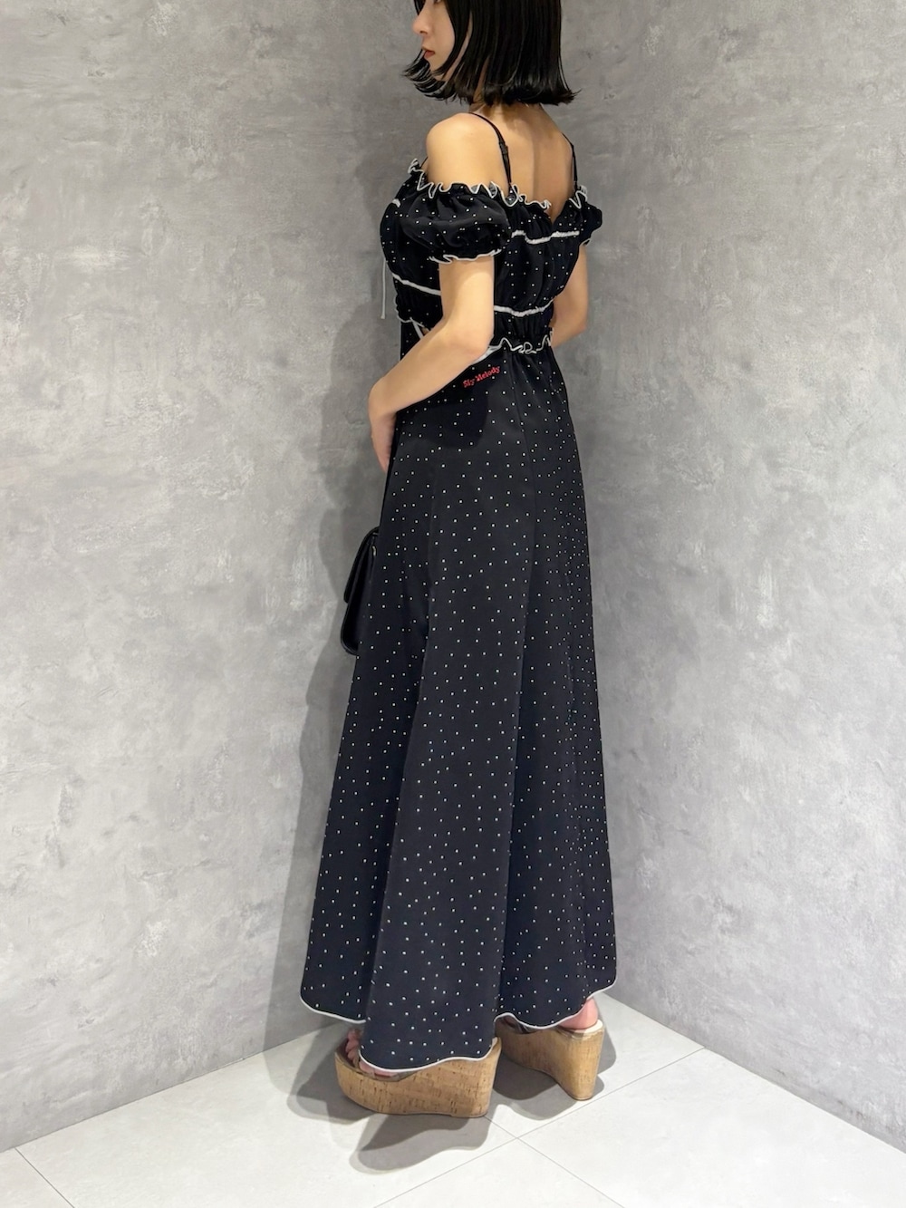 ブラック系のワンピース、ブラウン系のサンダル、ブラック系のショルダーバッグを着用したレディースの春コーディネートの3枚目の写真