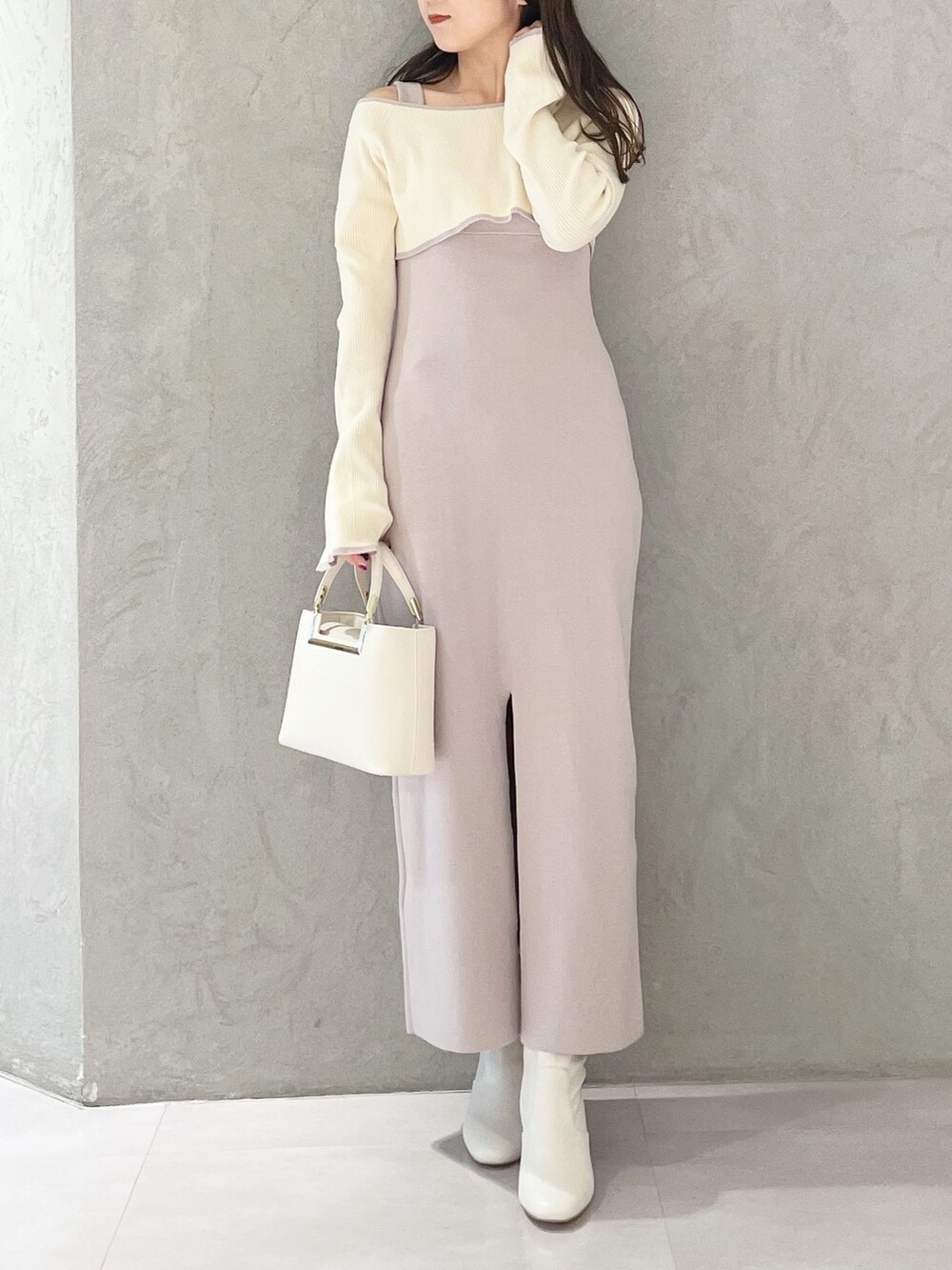 ピンク系のワンピース、ホワイト系のハンドバッグ、ホワイト系のブーツを着用したレディースの秋コーディネートの2枚目の写真