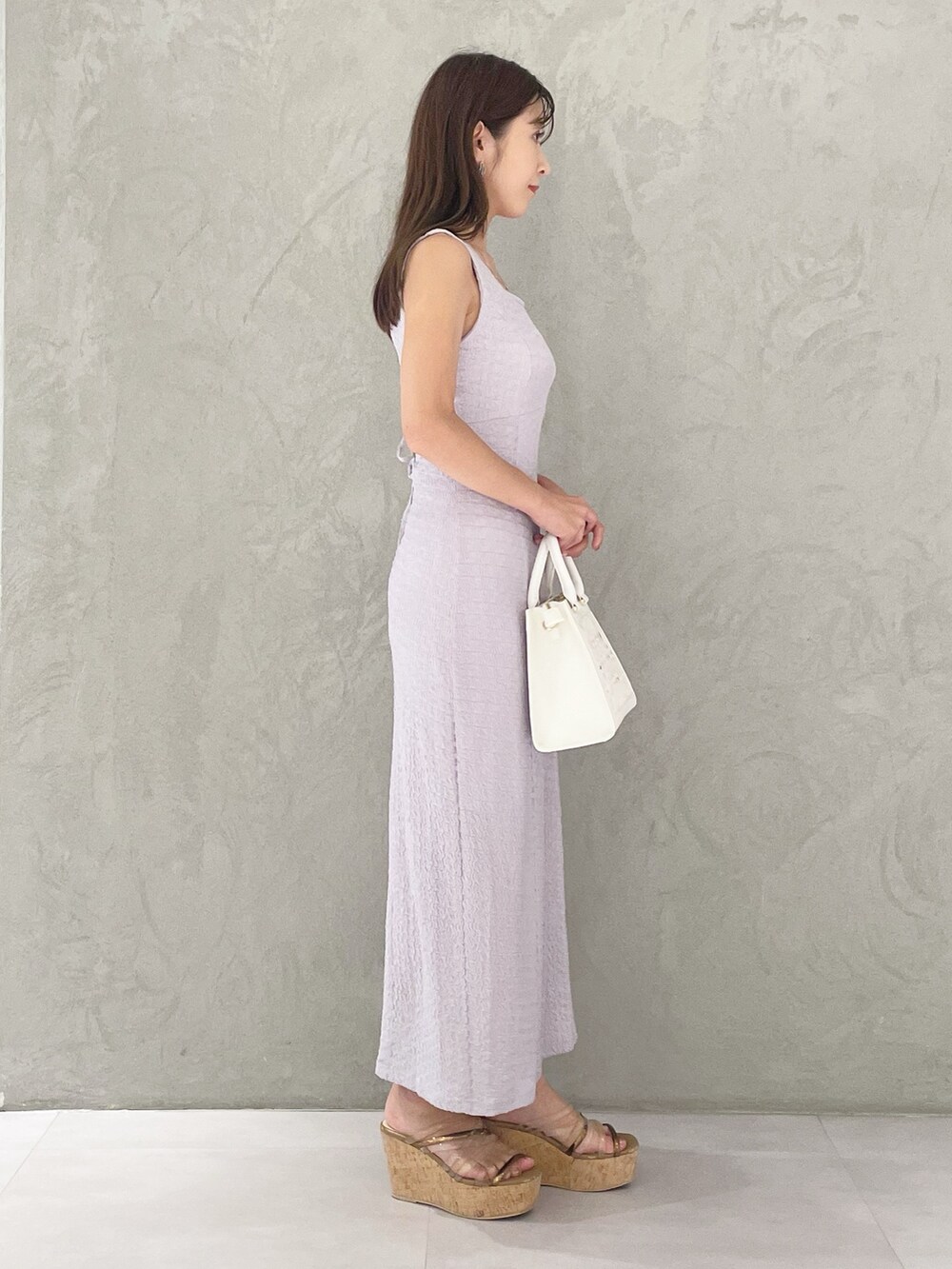 ホワイト系のショルダーバッグ、ブラウン系のサンダル、パープル系のワンピースを着用したレディースの夏コーディネートの2枚目の写真