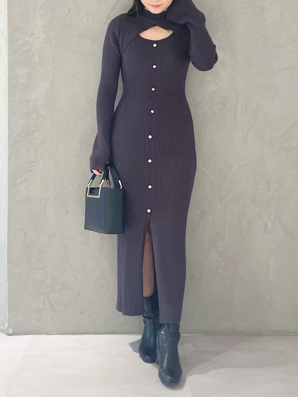 ブラック系のハンドバッグ、ブラック系のブーツ、グレー系のワンピースを着用したレディースの冬コーディネートの5枚目の写真