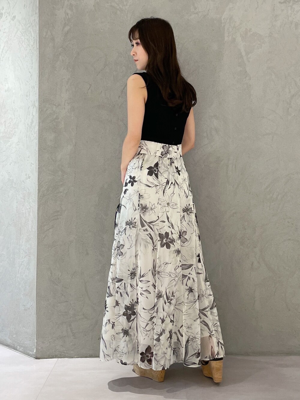 ホワイト系のボストンバッグ、ホワイト系のスカート、ブラック系のニット/セーターを着用したレディースの春コーディネートの3枚目の写真