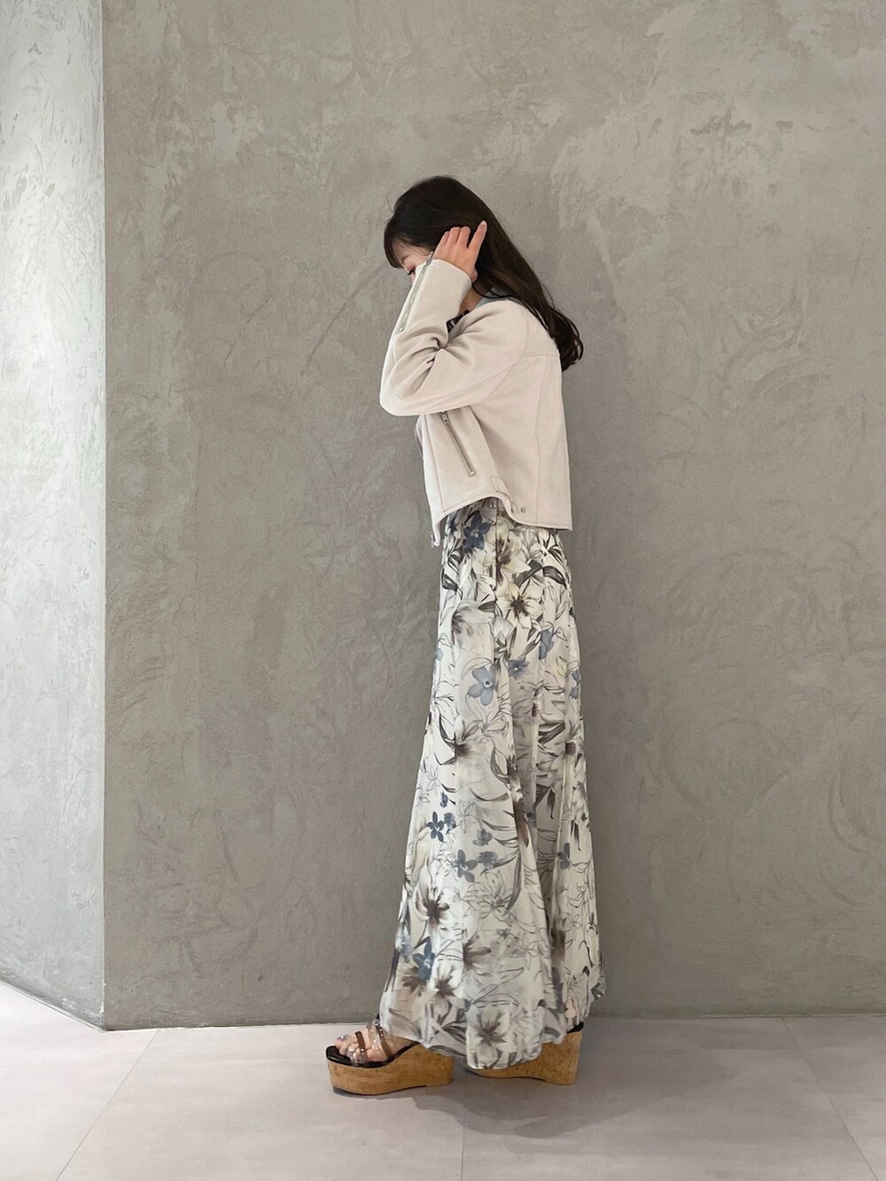 グリーン系のスカート、ピンク系のライダースジャケット、ブラック系のサンダルを着用したレディースの春コーディネートの3枚目の写真