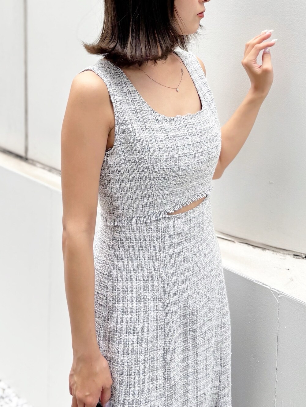 グレー系のワンピース、ホワイト系のサンダル、ブラック系のハンドバッグを着用したレディースの夏コーディネートの5枚目の写真