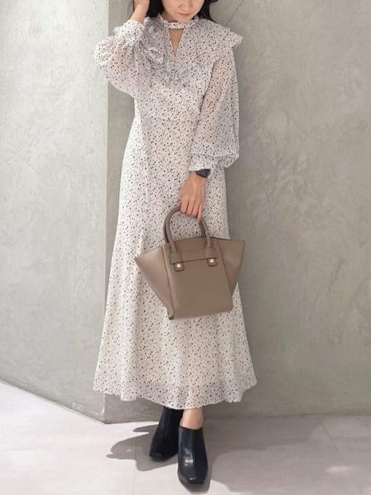 ブラウン系のハンドバッグ、ホワイト系のワンピース、ブラック系のサンダルを着用したレディースの夏コーディネートの4枚目の写真