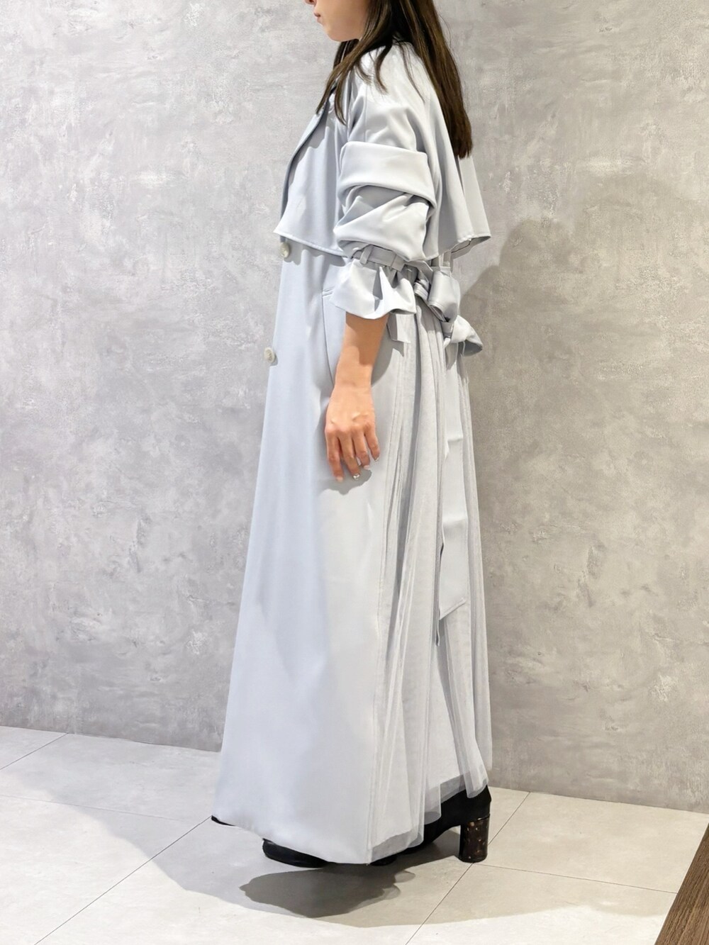 ブラック系のスカート、ブラック系のブーツ、ブラウン系のハンドバッグを着用したレディースの冬コーディネートの3枚目の写真