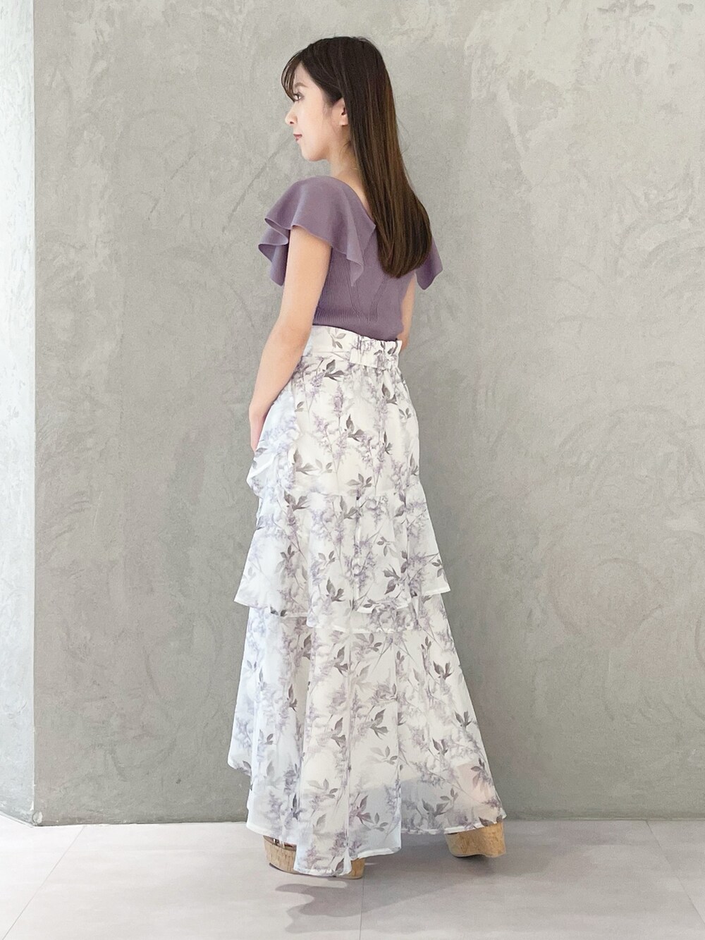 ホワイト系のハンドバッグ、パープル系のスカート、ブラウン系のサンダルを着用したレディースの春コーディネートの2枚目の写真