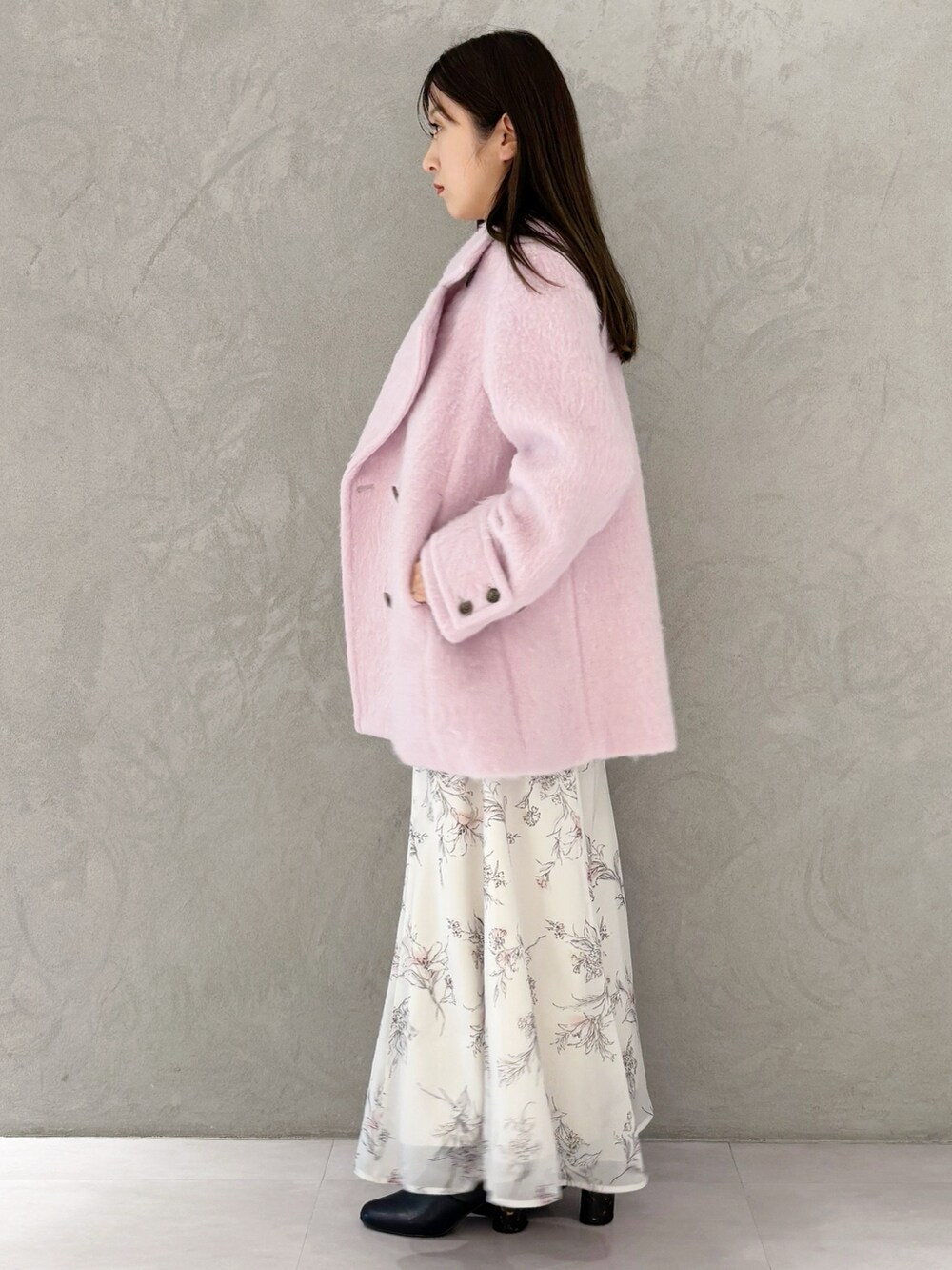 ベージュ系のワンピース、ブラック系のブーツ、ホワイト系のハンドバッグを着用したレディースの冬コーディネートの2枚目の写真