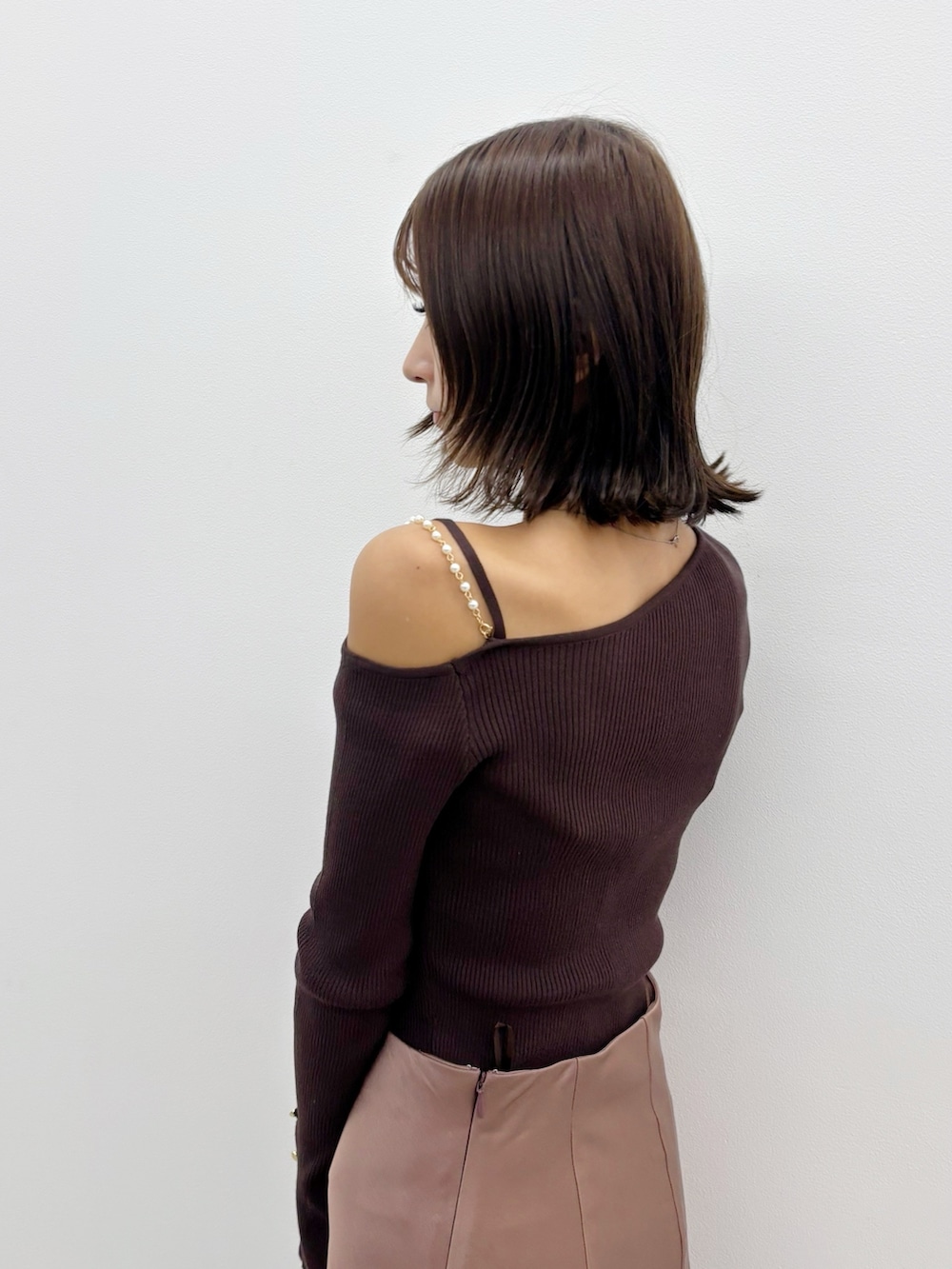 ブラウン系のスカート、ブラウン系のブーツ、ブラウン系のニット/セーターを着用したレディースの秋コーディネートの5枚目の写真