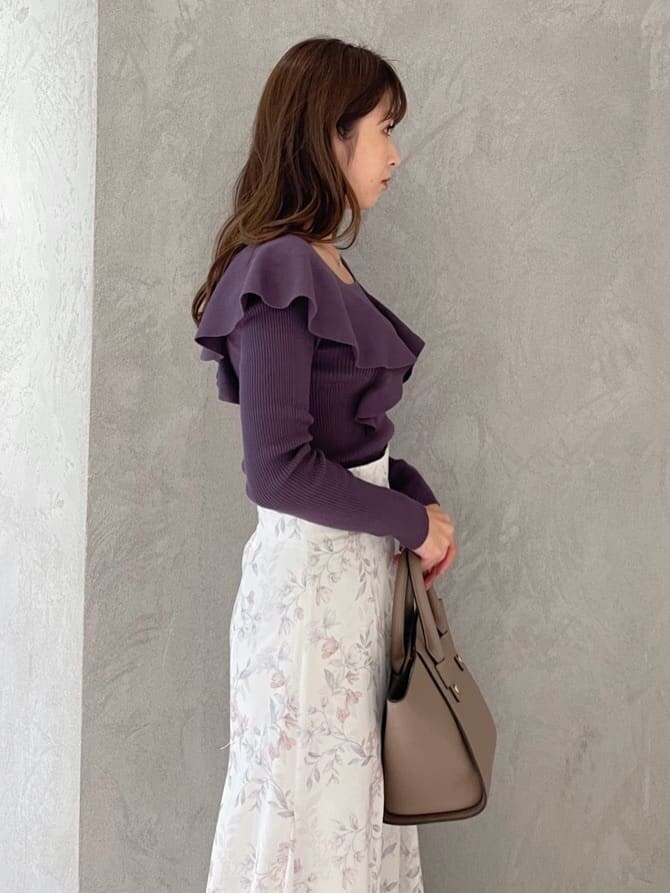 ピンク系のスカート、ブラウン系のハンドバッグ、パープル系のニット/セーターを着用したレディースの秋コーディネートの6枚目の写真