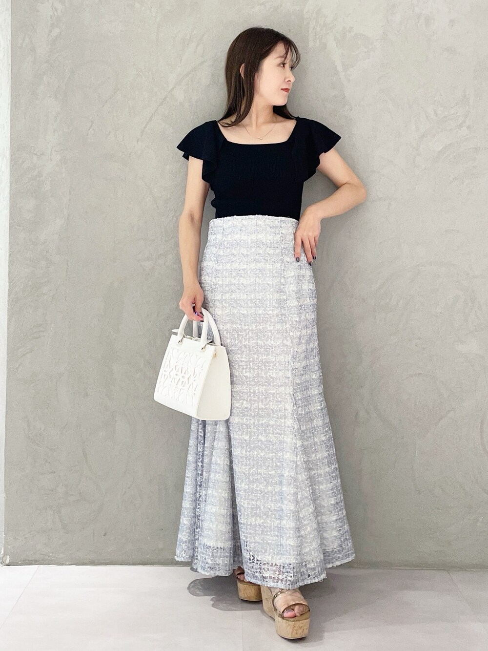 ホワイト系のショルダーバッグ、ブラック系のニット/セーター、ブラウン系のサンダルを着用したレディースの春コーディネートの5枚目の写真