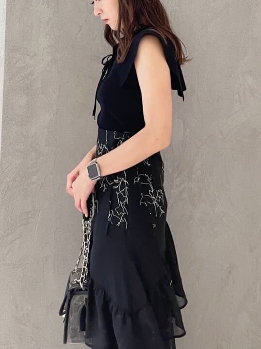 ブラック系のショルダーバッグ、ブラック系のニット/セーター、ブラック系のスカートを着用したレディースの夏コーディネートの3枚目の写真