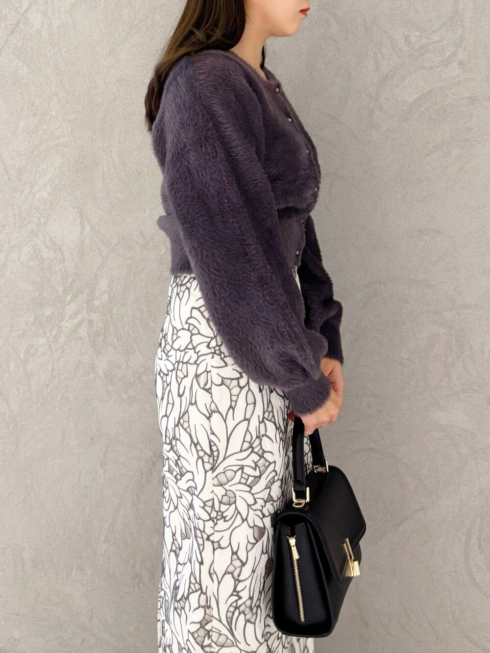 ホワイト系のスカート、ブラック系のブーツ、ブラック系のショルダーバッグを着用したレディースの冬コーディネートの3枚目の写真