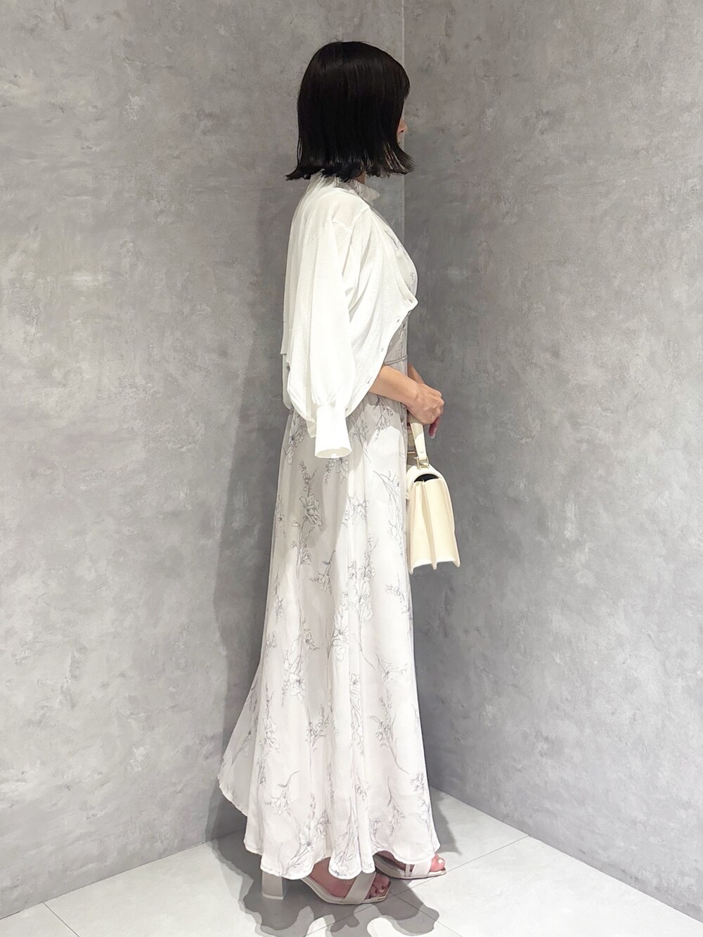 グレー系のワンピース、ホワイト系のカーディガン/ボレロ、ホワイト系のサンダルを着用したレディースの夏コーディネートの2枚目の写真