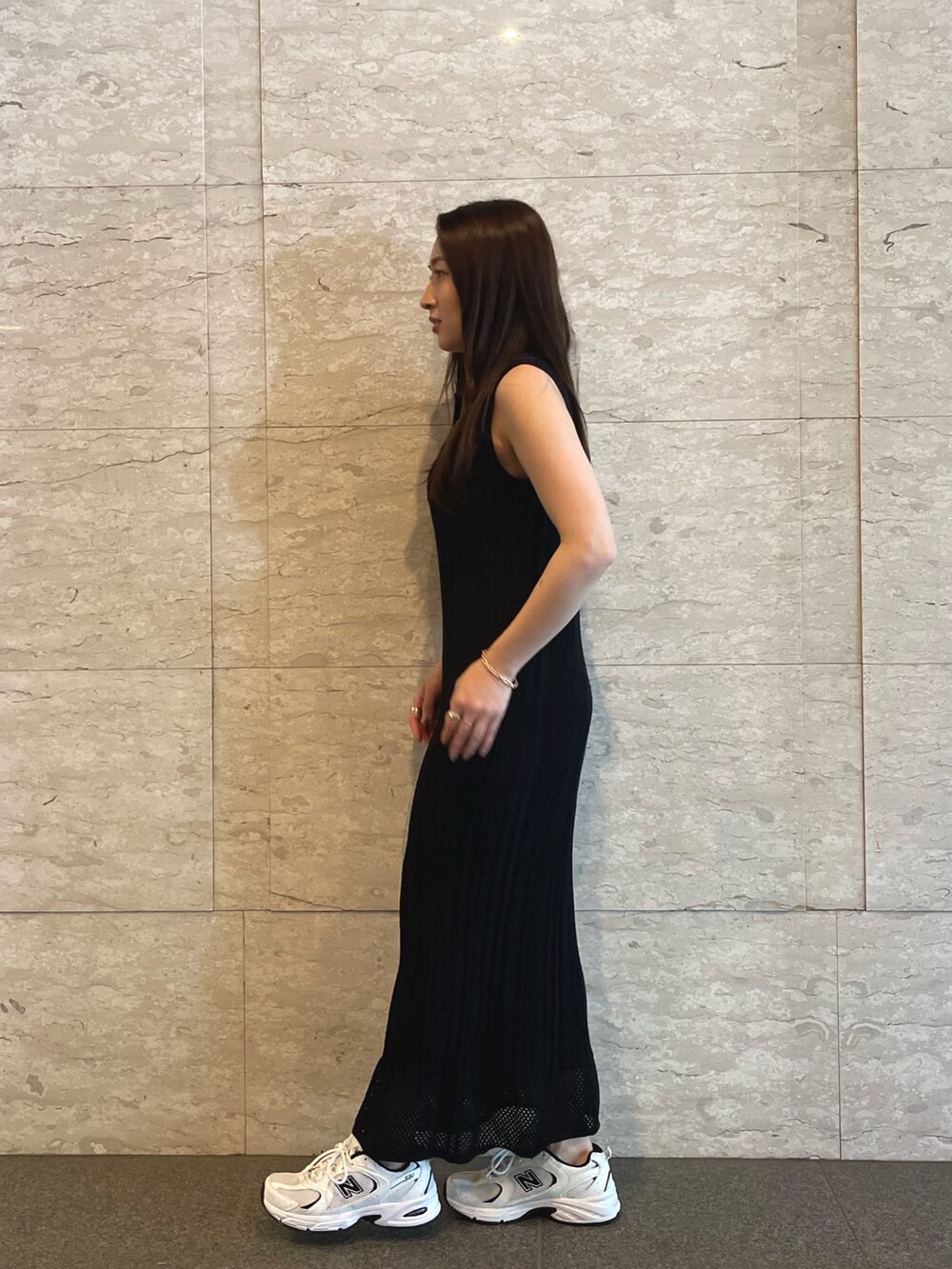 ブラック系のワンピース、ゴールド系のブレスレットを着用したレディースの夏コーディネートの3枚目の写真