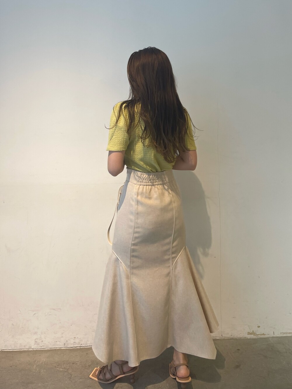 グリーン系のTシャツ/カットソー、ベージュ系のサンダル、ホワイト系のスカートを着用したレディースの春コーディネートの4枚目の写真