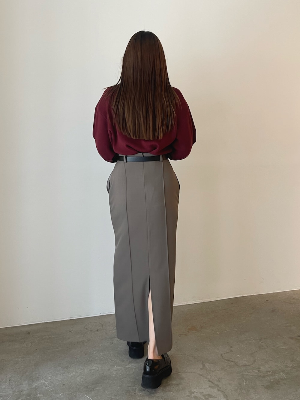 グレー系のスカート、レッド系のニット/セーターを着用したレディースの夏コーディネートの6枚目の写真