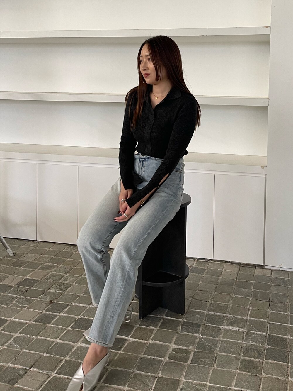 ブルー系のデニムパンツ、ブラック系のニット/セーターを着用したレディースの冬コーディネートの9枚目の写真