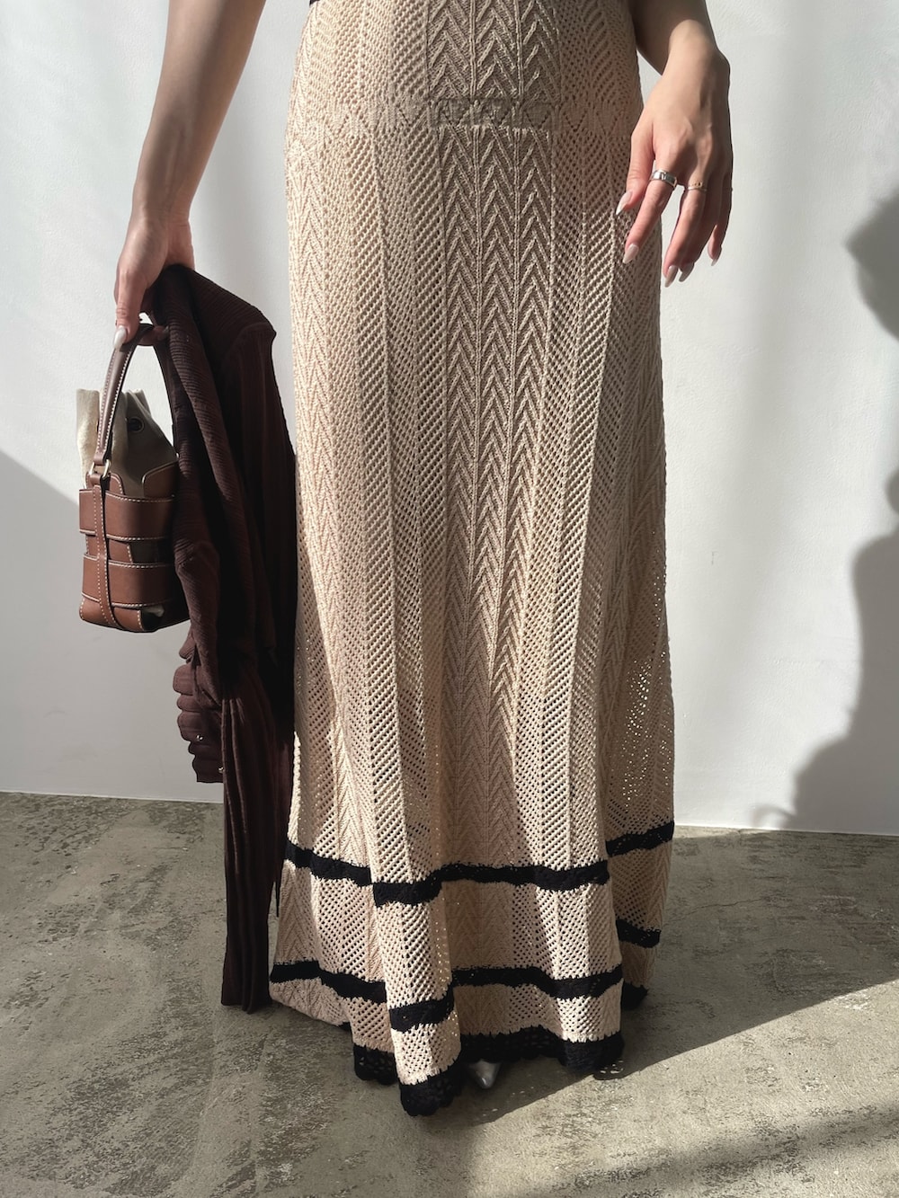 ベージュ系のワンピース、ブラウン系のカーディガン/ボレロ、シルバー系のパンプスを着用したレディースの春コーディネートの8枚目の写真