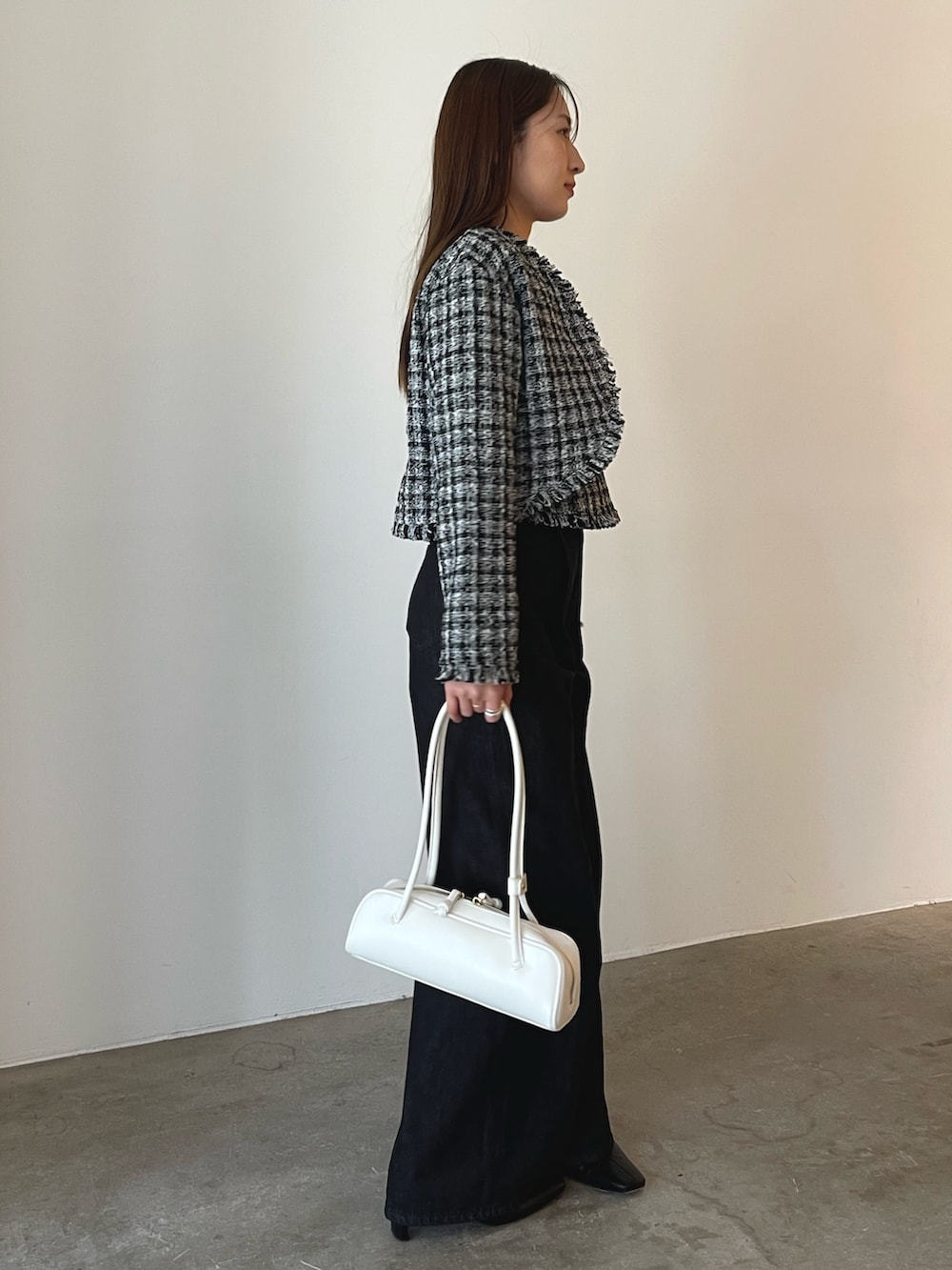 ホワイト系のショルダーバッグ、ブラック系のキャミソール、ブラック系のテーラードジャケットを着用したレディースの秋コーディネートの6枚目の写真