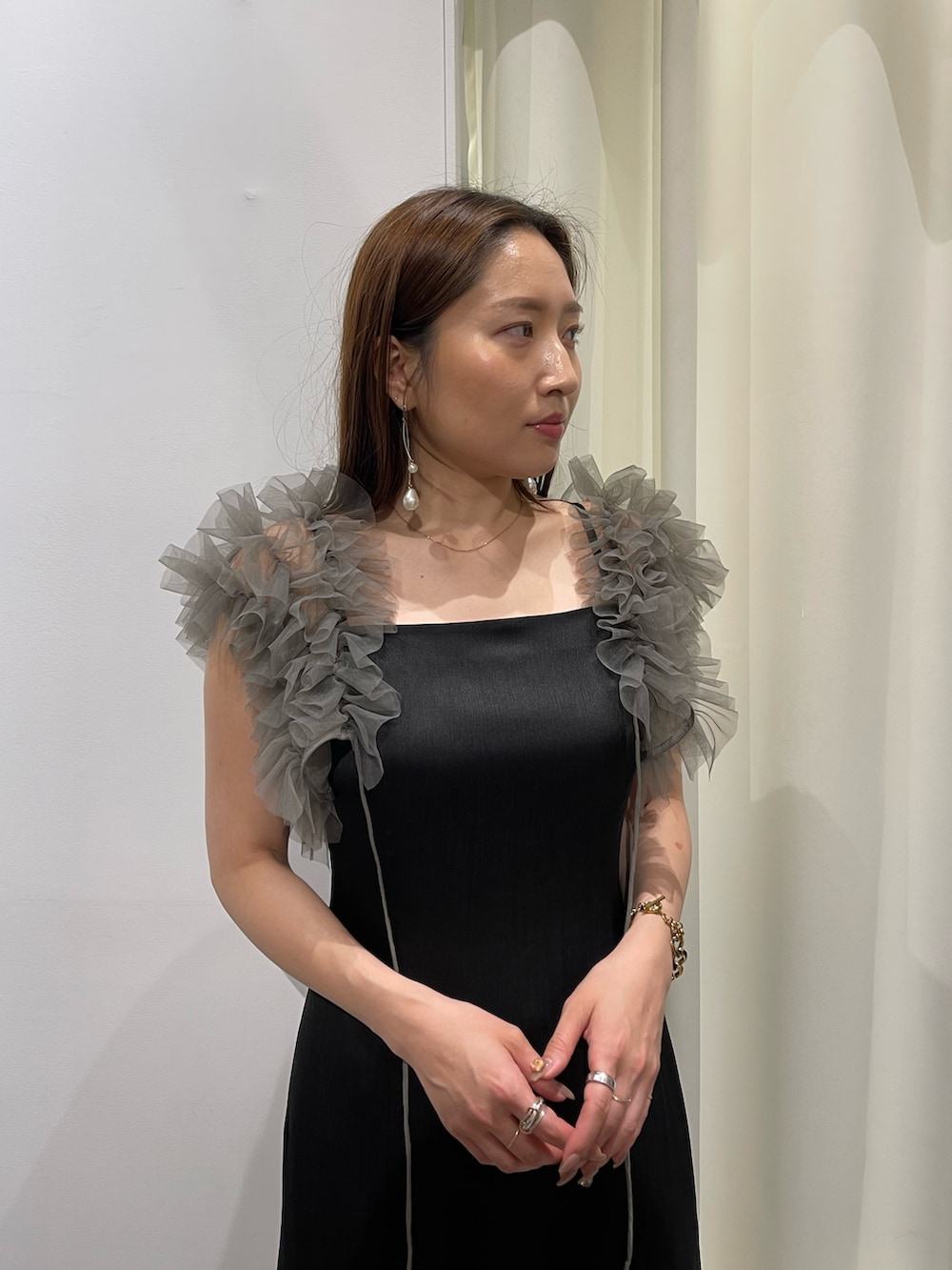 ブラック系のドレス、ゴールド系のピアス(両耳用)を着用したレディースの夏コーディネートの6枚目の写真