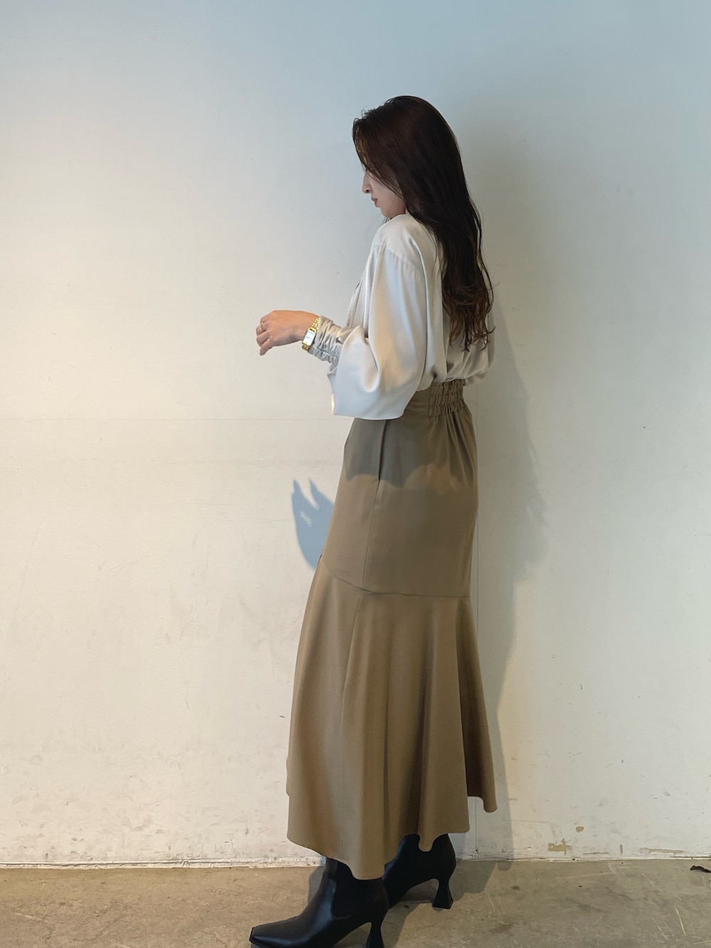 ホワイト系のシャツ/ブラウス、ベージュ系のスカートを着用したレディースの冬コーディネートの5枚目の写真