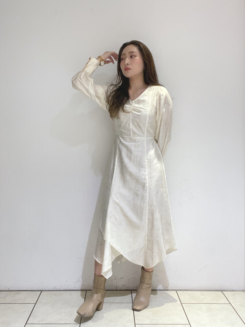 ベージュ系のブーツ、ホワイト系のワンピースを着用したレディースの冬コーディネートの3枚目の写真