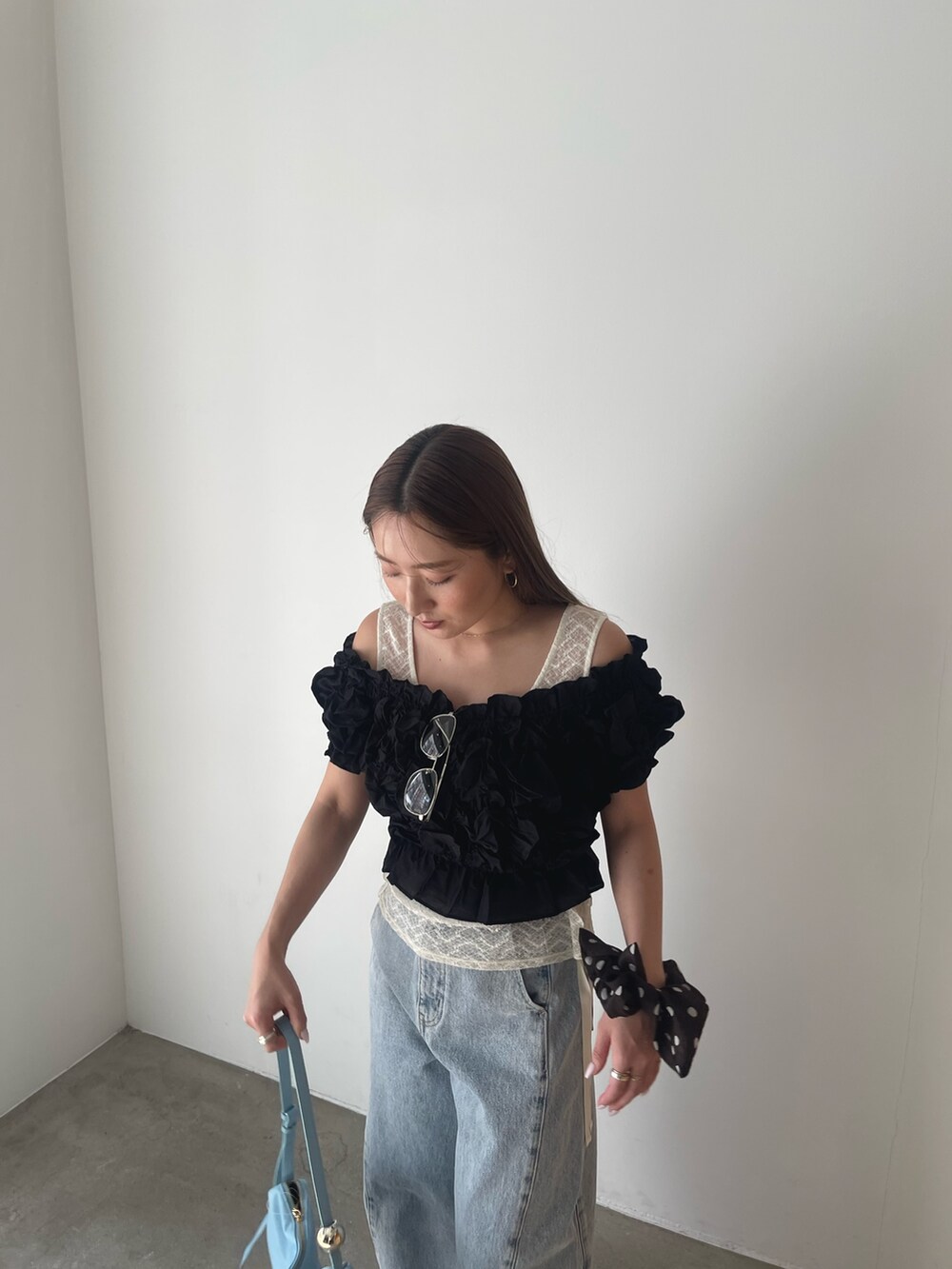 ブラック系のパンツドレス、ブルー系のデニムパンツ、ホワイト系のシャツ/ブラウスを着用したレディースの春コーディネートの7枚目の写真