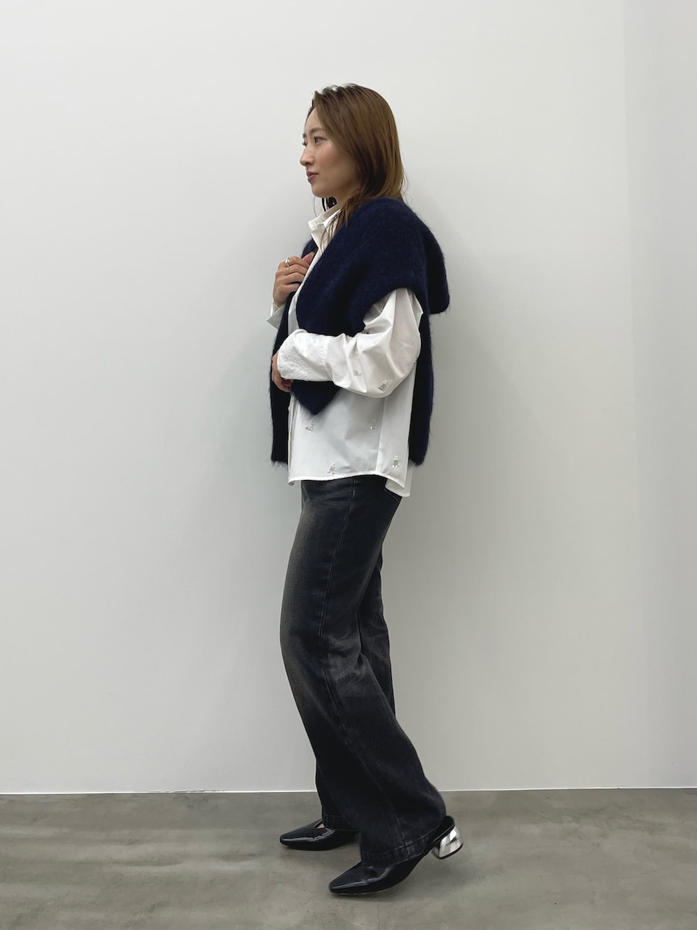 グレー系のデニムパンツ、ホワイト系のシャツ/ブラウス、ブルー系のカーディガン/ボレロを着用したレディースの秋コーディネートの3枚目の写真