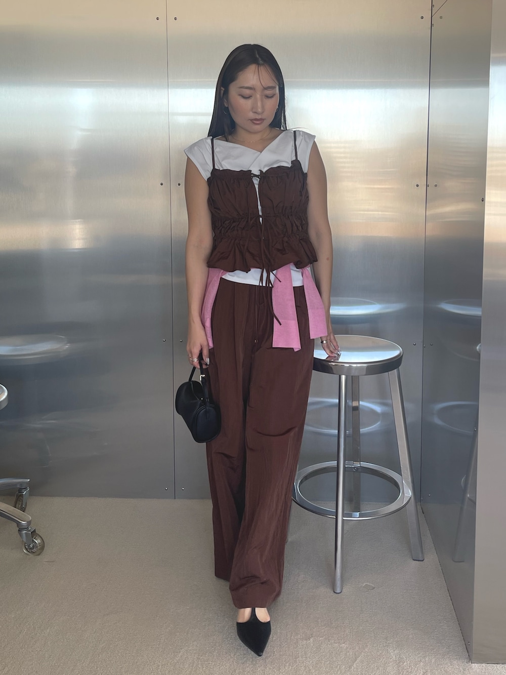 ブラック系のパンプス、ホワイト系のTシャツ/カットソー、ブラウン系のキャミソールを着用したレディースの春コーディネートの2枚目の写真