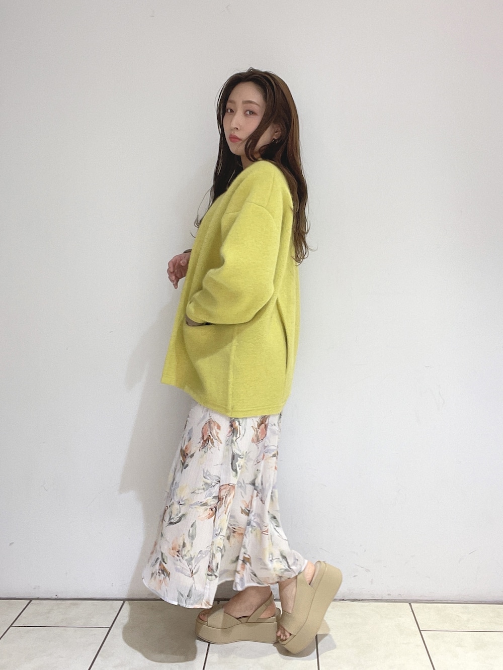 ホワイト系のワンピース、イエロー系のカーディガン/ボレロ、ベージュ系のサンダルを着用したレディースの冬コーディネートの3枚目の写真