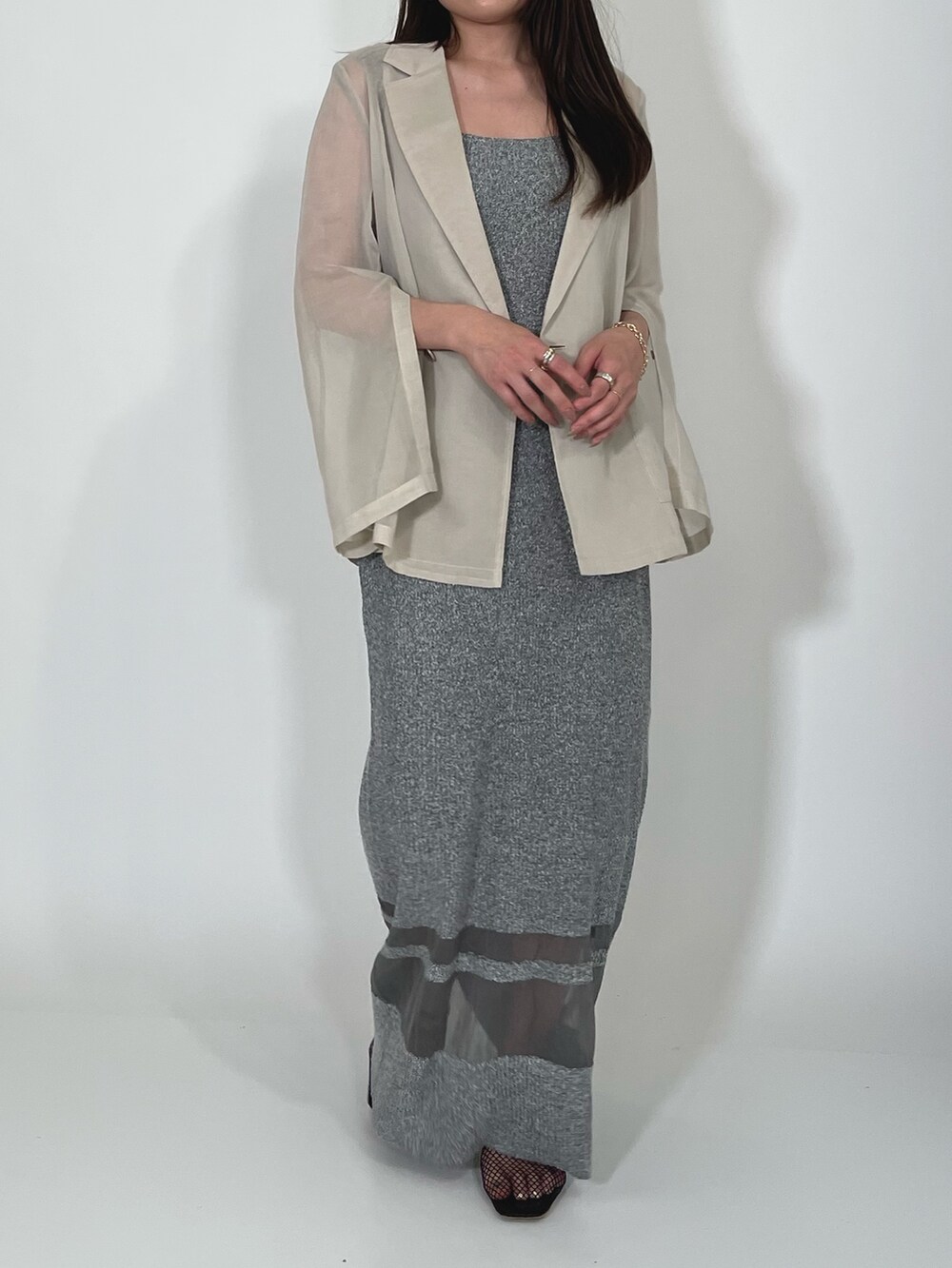 ホワイト系のテーラードジャケット、グレー系のワンピース、ブラック系のサンダルを着用したレディースの夏コーディネートの6枚目の写真