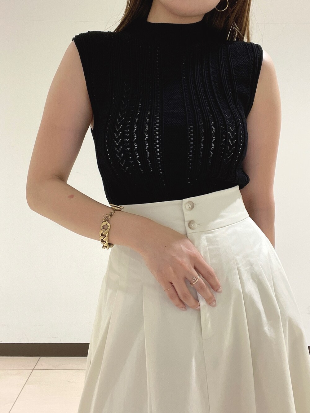 ブラック系のニット/セーター、ホワイト系のスカート、その他のサンダルを着用したレディースの夏コーディネートの8枚目の写真