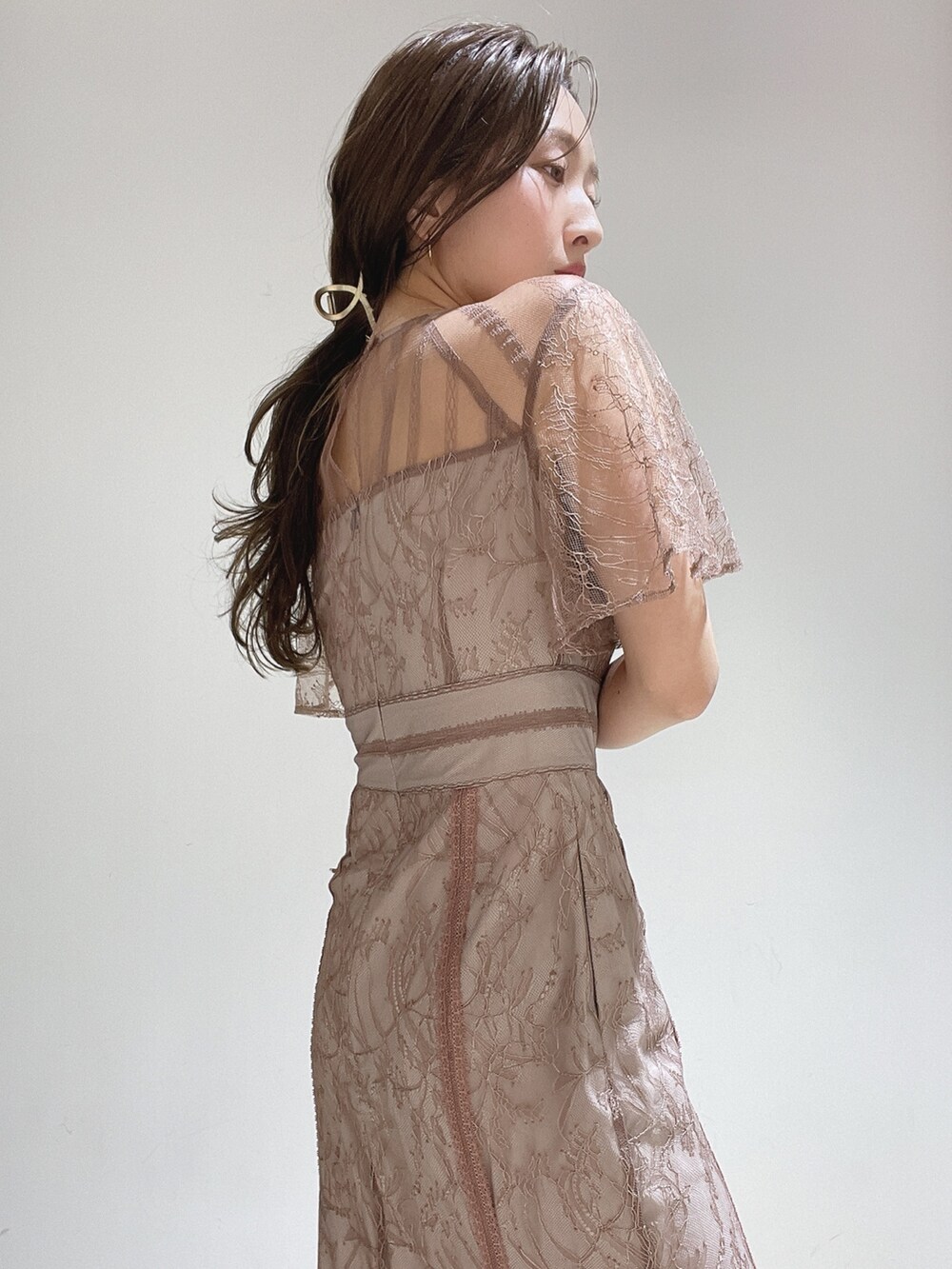 ブラウン系のドレス、ゴールド系のパンプス、ゴールド系のハンドバッグを着用したレディースの冬コーディネートの10枚目の写真