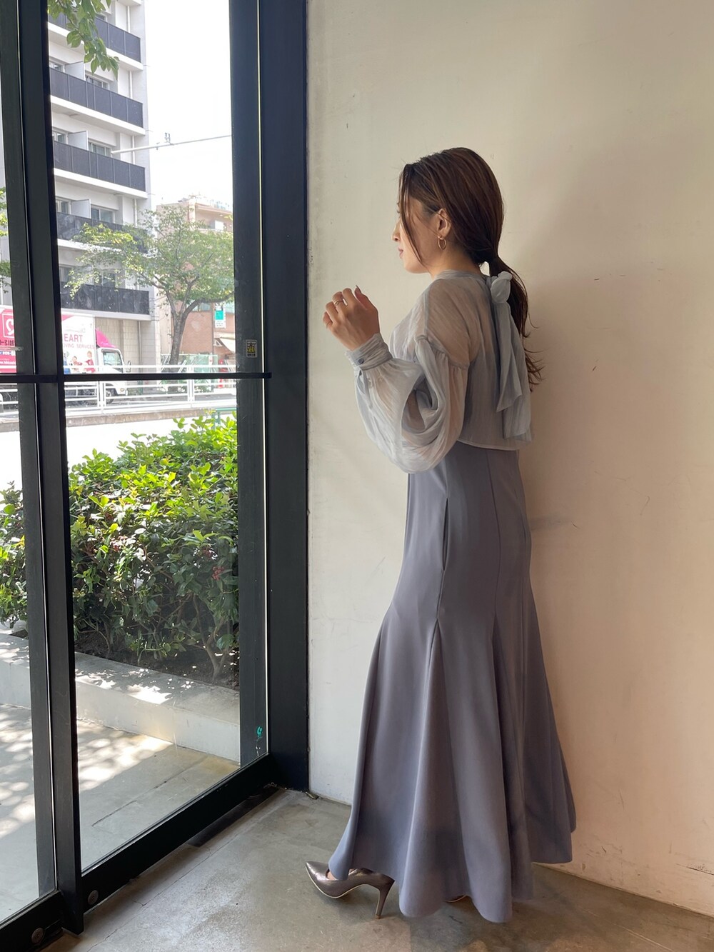 シルバー系のパンプス、ブルー系のドレスを着用したレディースの秋コーディネートの4枚目の写真