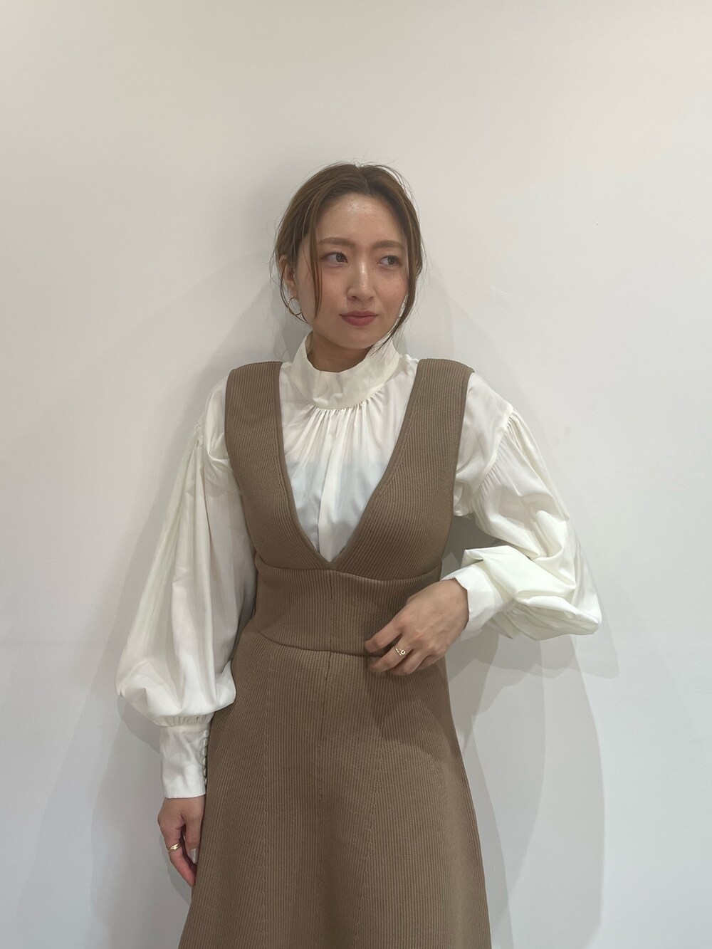 ベージュ系のジャンパースカート、ホワイト系のシャツ/ブラウス、ブラック系のブーツを着用したレディースの秋コーディネートの6枚目の写真