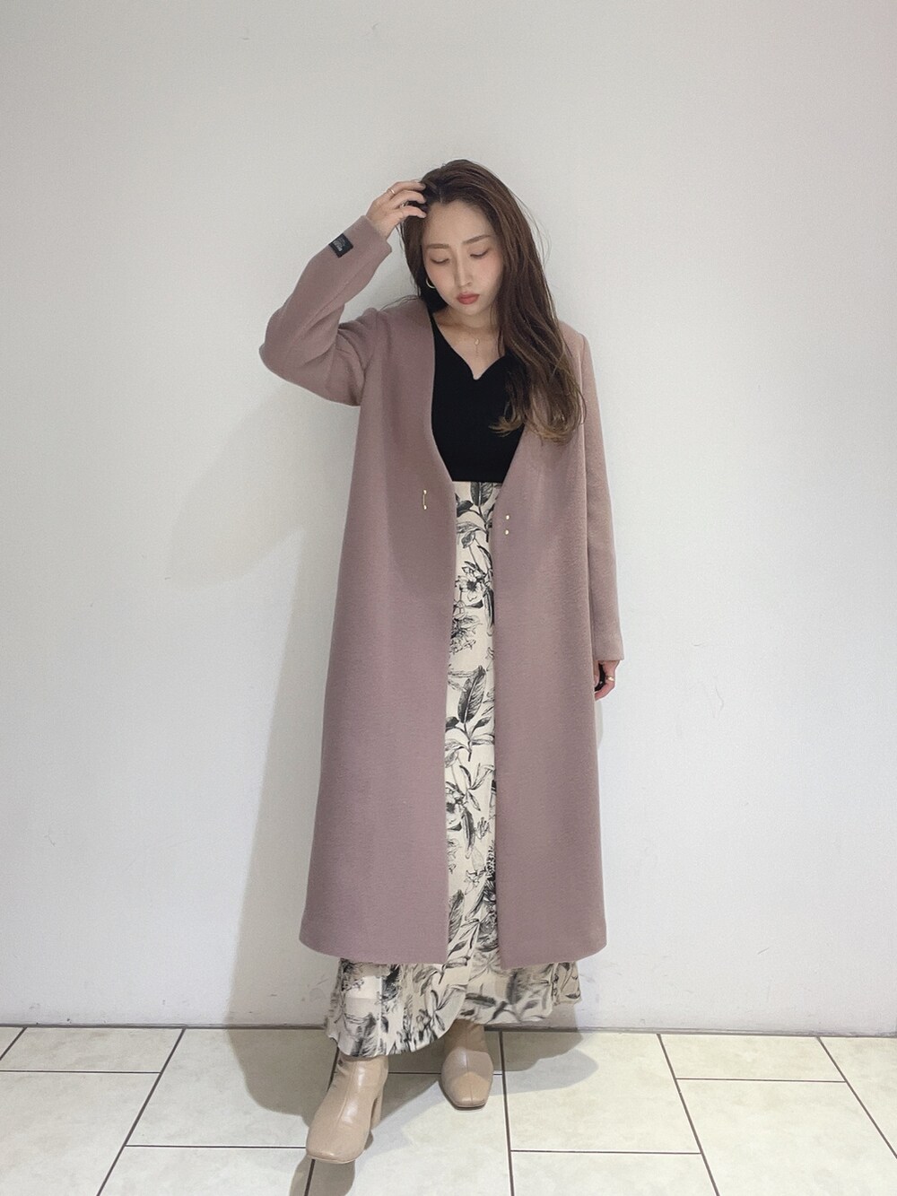 ベージュ系のスカート、ブラック系のニット/セーターを着用したレディースの秋コーディネートの7枚目の写真