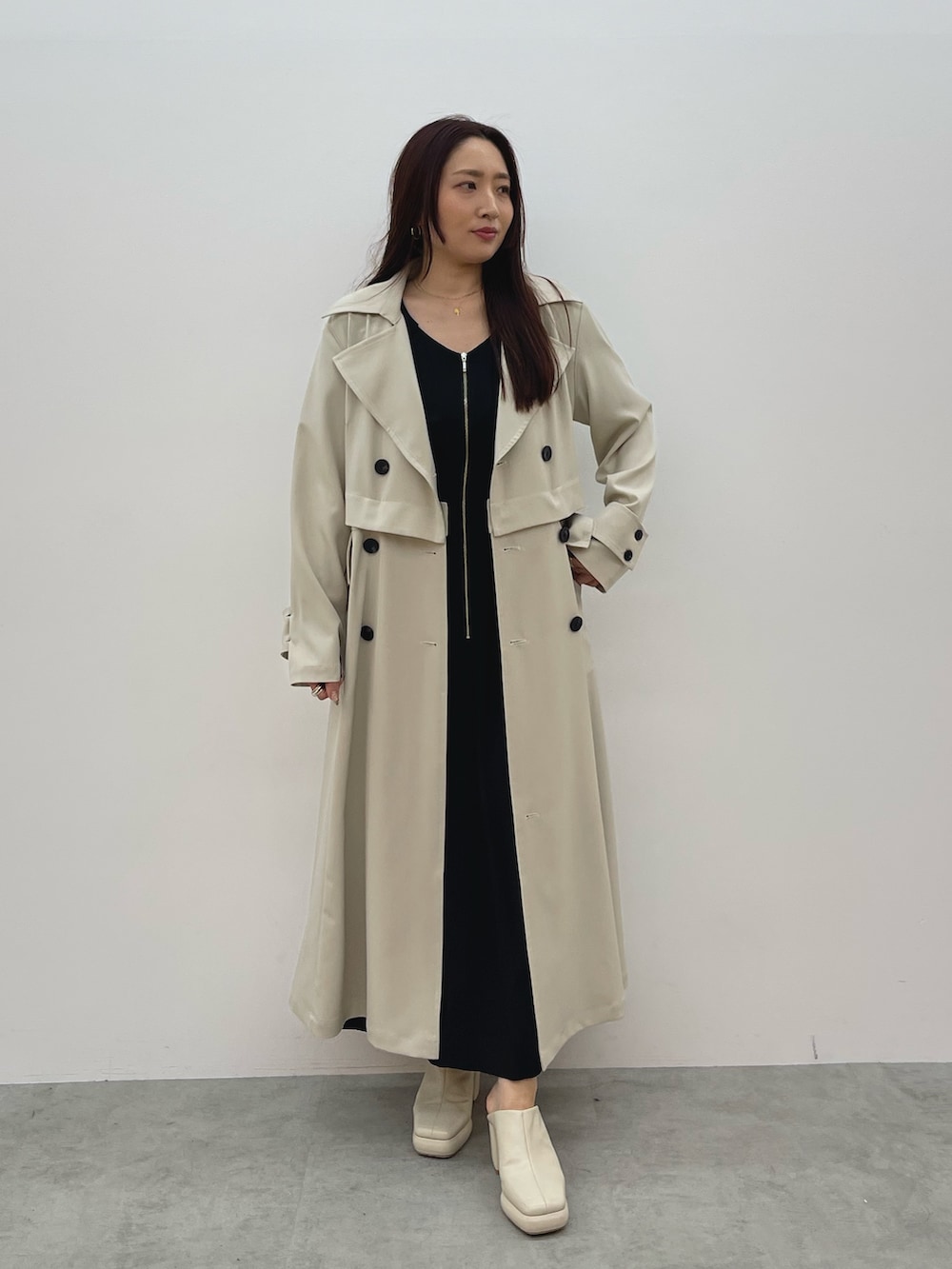 ホワイト系のトレンチコート、ブラック系のワンピース、ホワイト系のサンダルを着用したレディースの春コーディネートの8枚目の写真