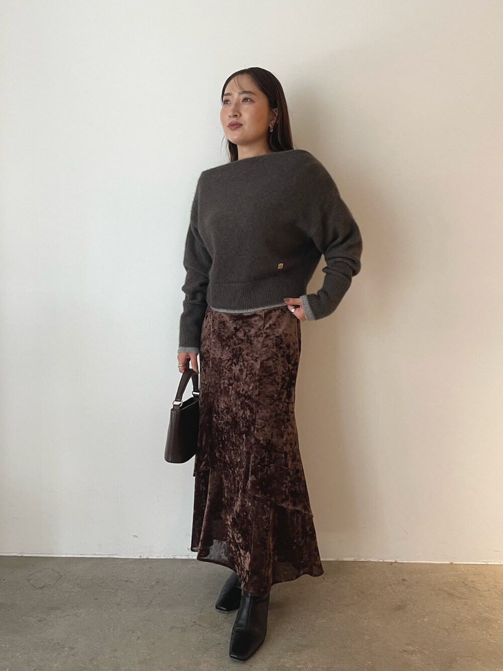 ブラウン系のハンドバッグ、ブラウン系のニット/セーター、ブラウン系のスカートを着用したレディースの秋コーディネートの8枚目の写真