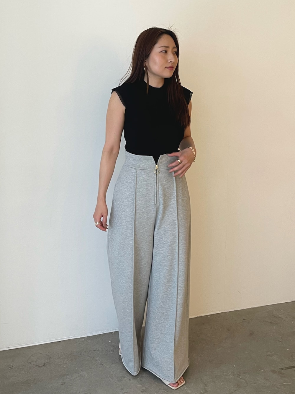 グレー系のスウェットパンツ、ホワイト系のサンダル、ブラック系のニット/セーターを着用したレディースの春コーディネートの5枚目の写真