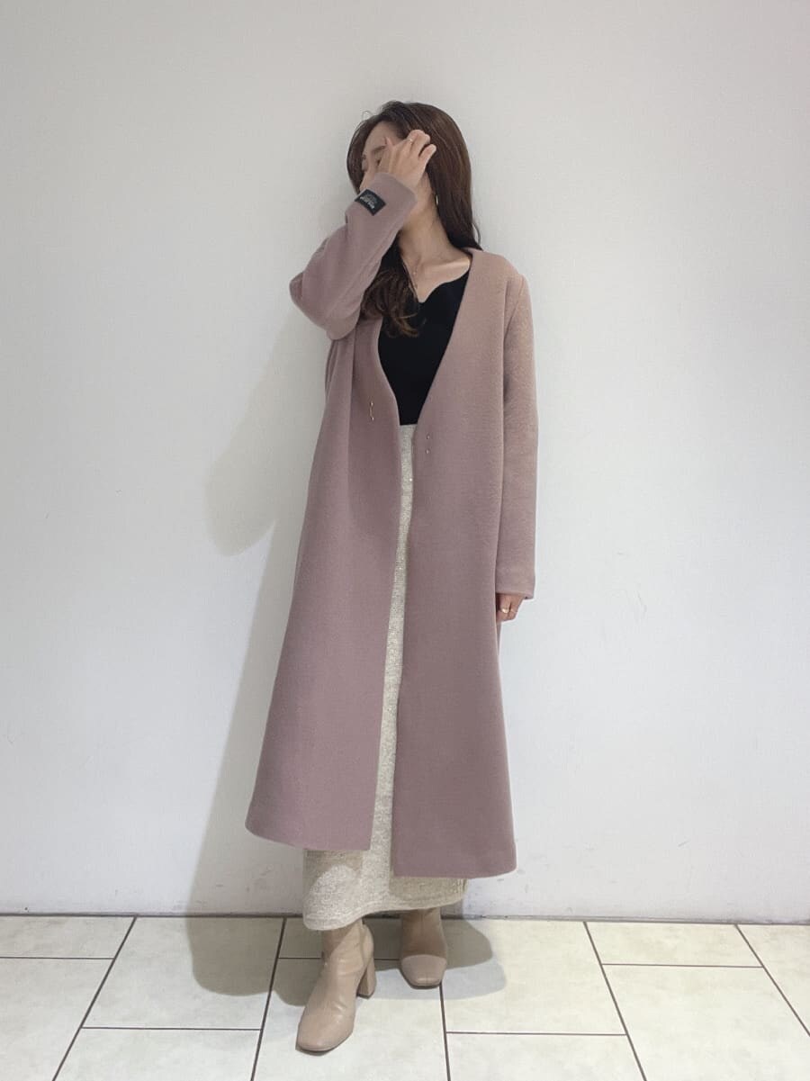ベージュ系のブーツ、ピンク系のノーカラーコート、ブラック系のニット/セーターを着用したレディースの秋コーディネートの4枚目の写真