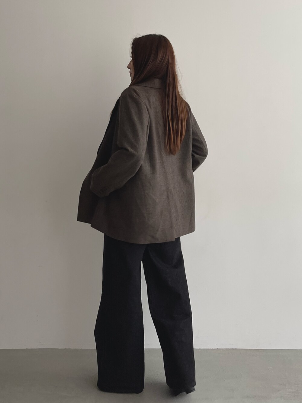 ブラック系のデニムパンツ、グレー系のニット/セーター、ブラウン系のテーラードジャケットを着用したレディースの夏コーディネートの7枚目の写真