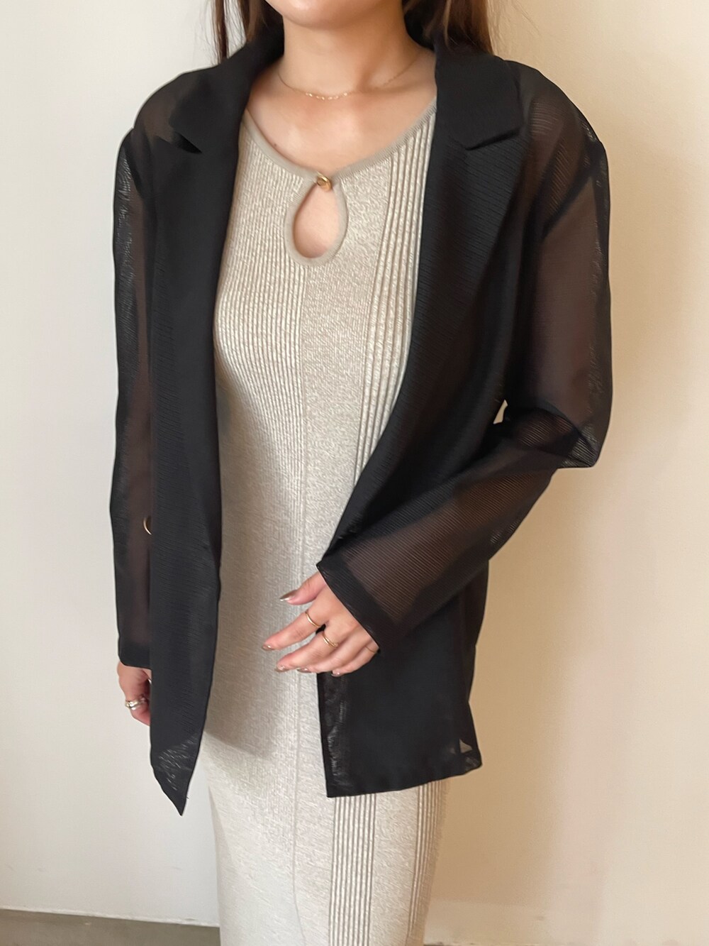 ベージュ系のワンピース、ブラック系のテーラードジャケット、ベージュ系のパンプスを着用したレディースの夏コーディネートの6枚目の写真