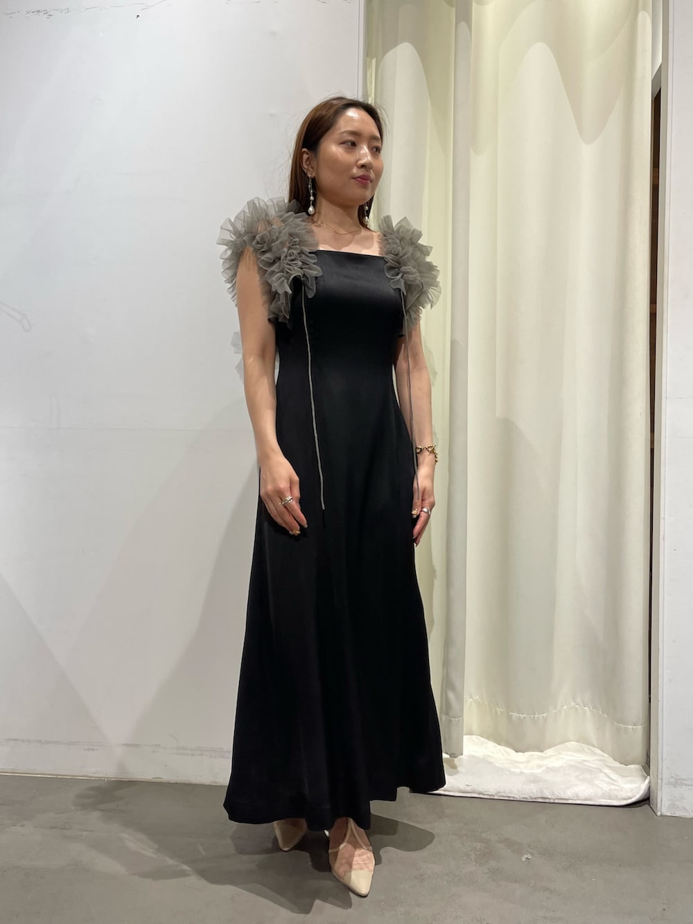 ブラック系のドレス、ゴールド系のピアス(両耳用)を着用したレディースの夏コーディネートの3枚目の写真